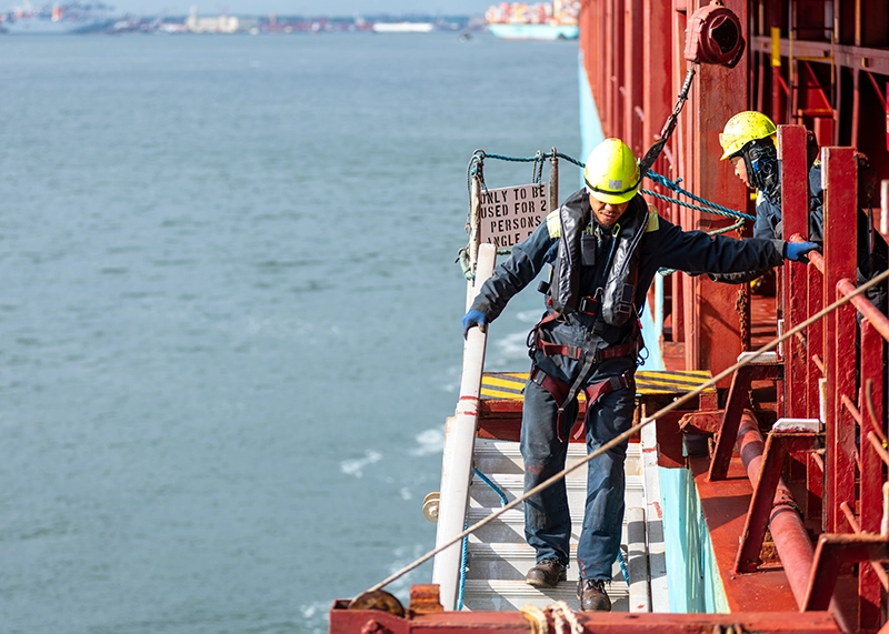 Port Maintenance worker preparing port for ship arrival.